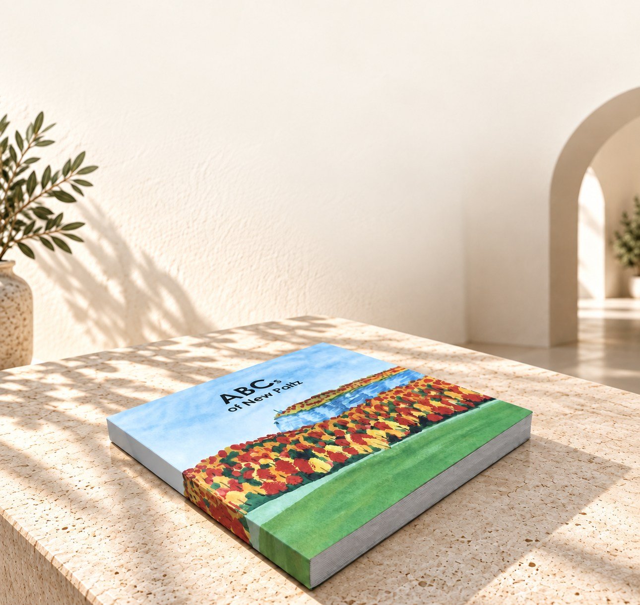 ABCs of New Paltz hardcover presented on a pale stone display with a styled architectural background