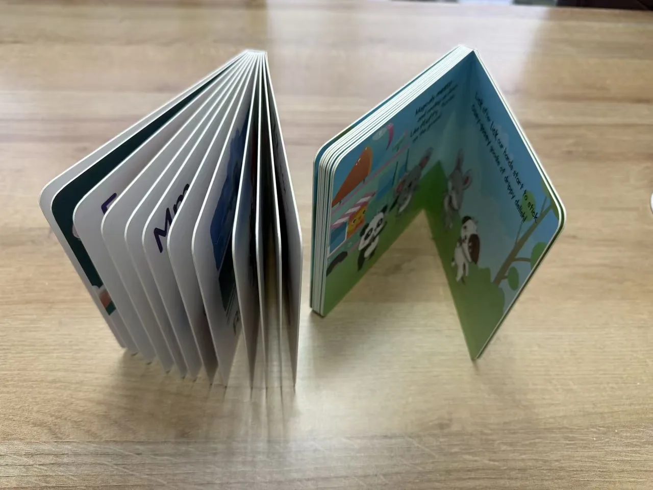 Two children's books standing open to show rounded page edges and binding